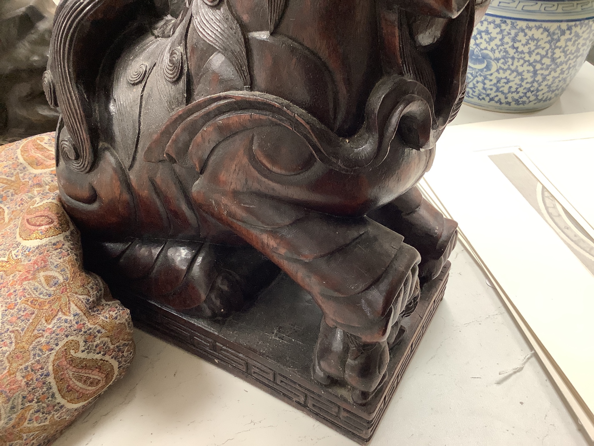 A pair of Chinese carved hardwood Buddhist lions, width 26cm height 37cm